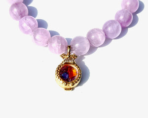 Kunzite is an emblem of the peach and lavender rays of Light, and radiates with unconditional Love. It vibrates at a frequency similar to Lady Guanyin's Love energy.  Kunzite beads bracelet with an 18k gold beads and on the opposite side a miniature treasure box, with magickal dusts inside.   The miniature treasure box is made of 18k yellow gold and white diamonds. It has a small Vajra on top of it.  Stretch bracelet
