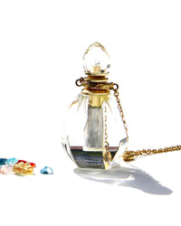 The Flame of Devotion ... to the Light.  I am Light ... I am of the Light... and I serve the Light.  The crystal has been carved in a small Flame.  The Elixirs of Light or any diluted essential oils can be stored inside.  The necklace can be opened and used for the Flame of Devotion as well as the Vase of compassion.   Dimension: 4,2cms. Weight 12.5 gr  18k Necklace with 4 white sapphires: 62 cms plus 5cms extension.
