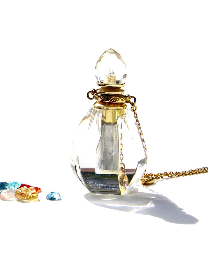 The Flame of Devotion ... to the Light.  I am Light ... I am of the Light... and I serve the Light.  The crystal has been carved in a small Flame.  The Elixirs of Light or any diluted essential oils can be stored inside.  The necklace can be opened and used for the Flame of Devotion as well as the Vase of compassion.   Dimension: 4,2cms. Weight 12.5 gr  18k Necklace with 4 white sapphires: 62 cms plus 5cms extension.
