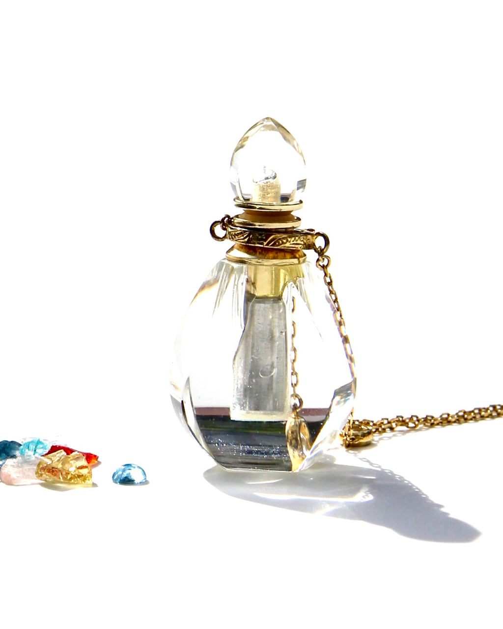 The Flame of Devotion ... to the Light.  I am Light ... I am of the Light... and I serve the Light.  The crystal has been carved in a small Flame.  The Elixirs of Light or any diluted essential oils can be stored inside.  The necklace can be opened and used for the Flame of Devotion as well as the Vase of compassion.   Dimension: 4,2cms. Weight 12.5 gr  18k Necklace with 4 white sapphires: 62 cms plus 5cms extension.