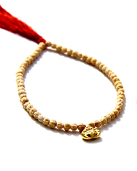 The Minis, a collection of tiny bracelets exploring the Universe of symbolism, made of Rudraksha beads strung on red thread, gold beads ....   This bracelet is made of Rudraksha beads with a 24k small laughing buddha.  Buddha size: 8mm